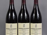 three bottles of wine are lined up on a table