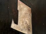 une image représentant une peinture d'une lettre « l » sur fond noir