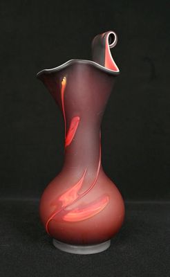 un vase en verre rouge orné d'un tourbillon rouge