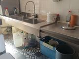 une cuisine équipée d'un évier, d'une cuisinière et d'une poubelle