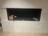 une télévision fixée au mur dans un coin de la pièce