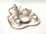 a tea set on a tray with cups and saucers
