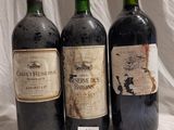 three bottles of wine are lined up on a table
