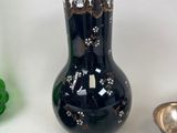 a black vase sitting on top of a table next to other decorative items