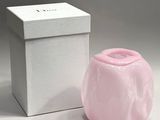 a small pink vase sitting next to a white box