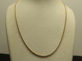 a white mannequin with a gold chain on it