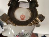 a vase with a bird on it sitting on a table