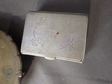 a small silver box sitting on a table next to a clock
