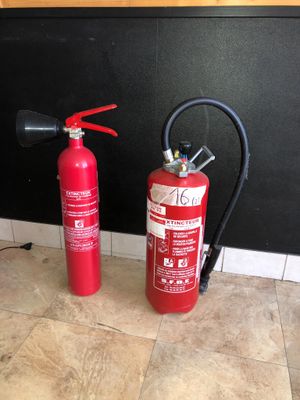 two fire extinguisors sitting on the floor next to each other