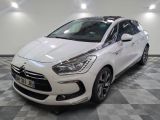 la voiture blanche est garée sur un sol en damier dans le garage