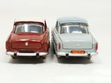 two toy cars sitting next to each other on a white surface