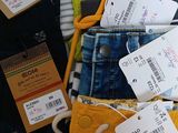 a pile of clothes with tags on them on a table