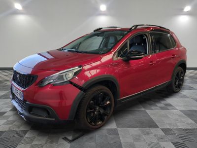 a red car is parked in a room with a checkered floor