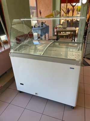 an ice cream shop with a glass display case on the counter