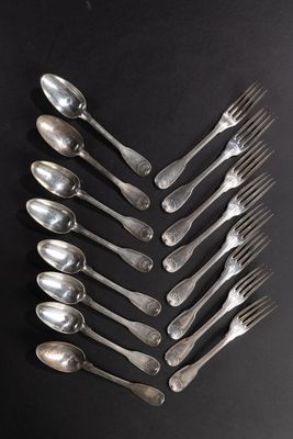 un grand nombre de cuillères et de fourchettes disposées sur une table