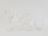 several empty wine glasses are lined up on a white surface