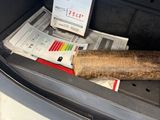 a newspaper in the trunk of a car with a stick of wood in it