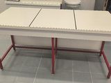 a white table with two red legs in a room