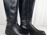 une paire de bottes en cuir noir avec des boucles de chaque côté