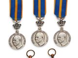 un ensemble composé de trois médailles et d'une médaille sur fond blanc