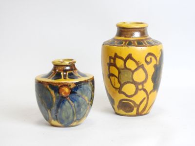 two vases sitting next to each other on a white surface