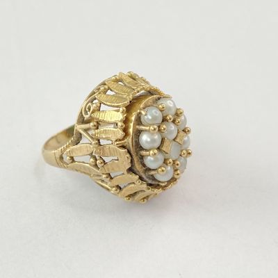 Gros plan sur une bague en or ornée de perles