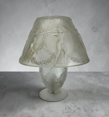 une lampe en verre munie d'un abat-jour blanc