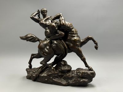 bronze statue of a man riding a horse on a rock
