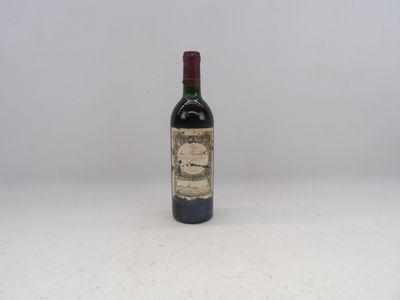 une vieille bouteille de vin posée sur une table blanche