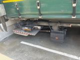 a green truck with a black box underneath it