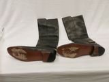 pair of black leather boots with brown soles sitting on a white surface
