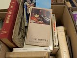 une boîte remplie de livres posés sur le sol
