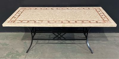 une table avec un plateau en mosaïque et des pieds en métal