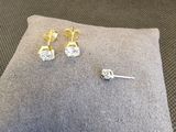 deux paires de boucles d'oreilles en diamant posées sur un coussin