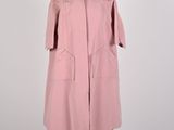 a pink coat on a mannequin stand with a white background