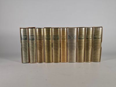 un ensemble de cinq livres anciens posés sur une surface blanche