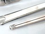 a pair of tonges sitting on a table next to a knife
