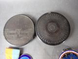 two medals and a coin sitting next to each other on a table