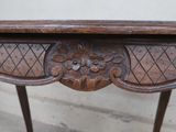a wooden table with carvings on the top of it
