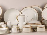 a lot of white and gold plates and cups