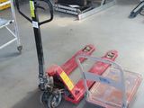 a red hand truck sitting on the floor in a garage