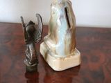 two figurines sitting on a wooden table next to each other