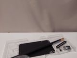 Le contenu d'un cahier noir, d'un stylo et d'un crayon est disposé sur une surface blanche.