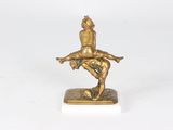 brass figurine of a man riding a horse on a white base