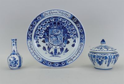 une assiette bleue et blanche et deux vases posés sur une table