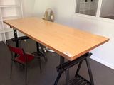 une table en bois avec une chaise rouge devant