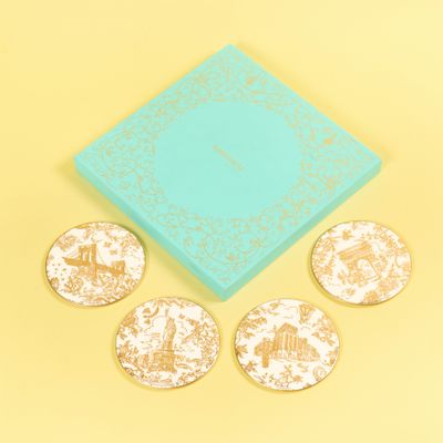 trois sous-verres dans une boîte bleue et quatre sous-verres ornés de motifs dorés