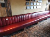 une banquette en cuir rouge dans un coin d'un restaurant