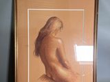 painting of a nude woman in a gold frame on a blue wall