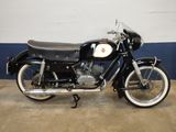 a black motorcycle parked in a garage with a blue wall